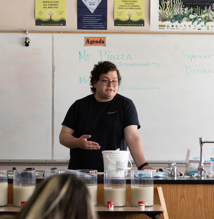 Project Engineer Joshua Martinez speaking in front of a classroom whtieboard