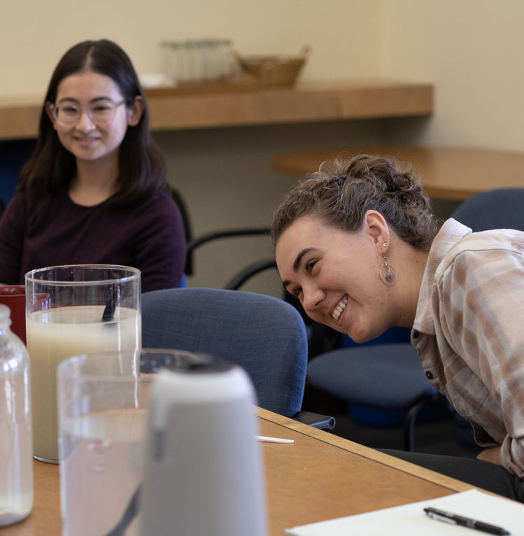 Interns looking into glass jar with dirty water