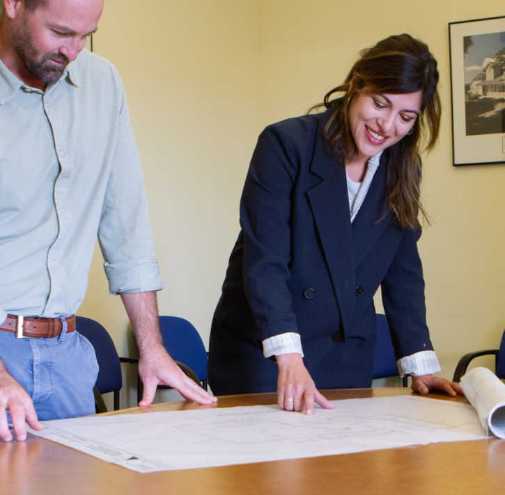 Two engineers looking over plans on a table