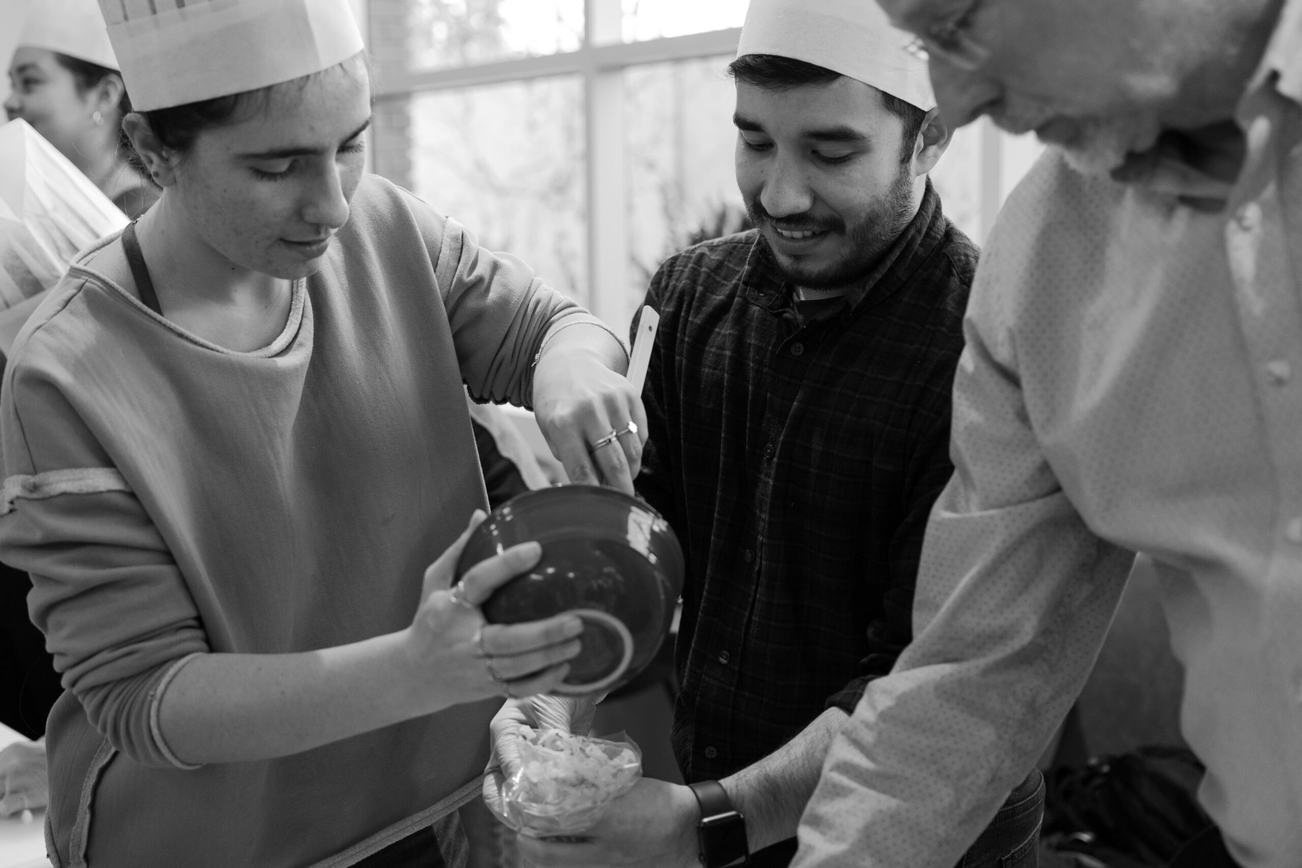 Black and white image of engineers stirring food in bowl