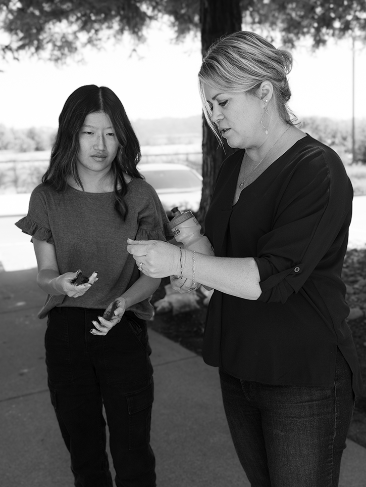 Intern and engineer conducting soil test black and white