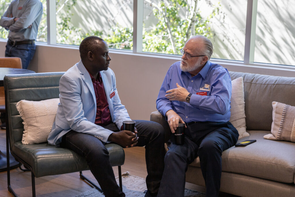 Two people sitting, talking at office event