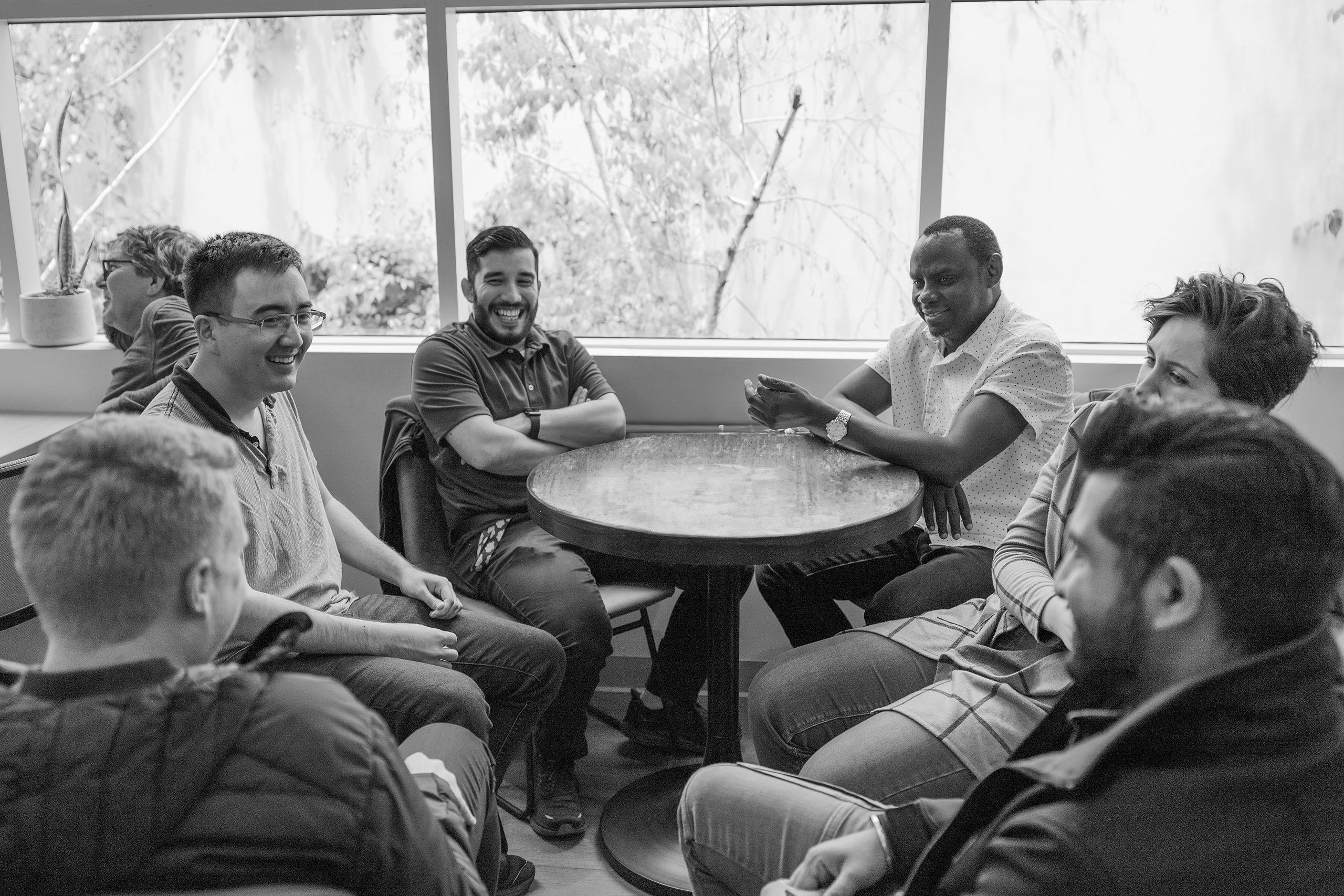 Group of people sitting around a table black and white